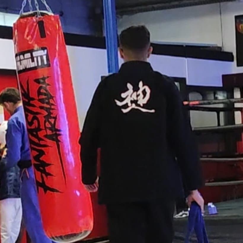 Ali, professeur, en kimono noir dans la salle.